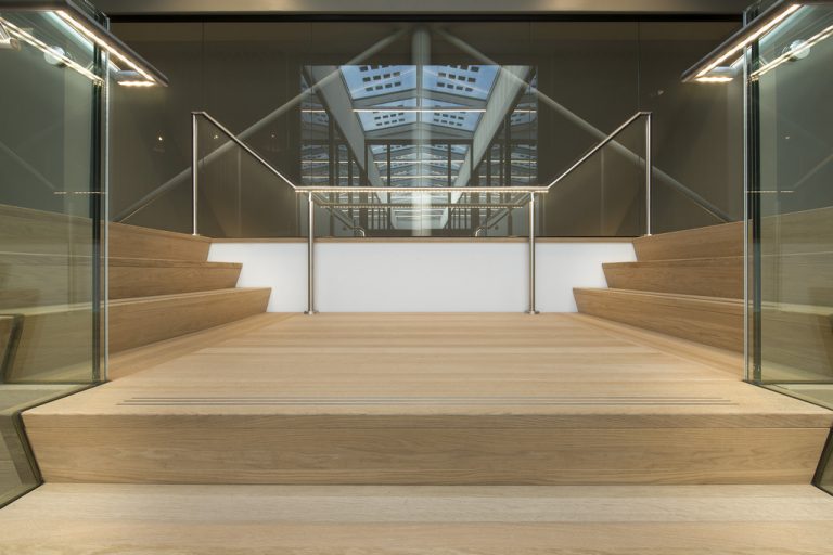 De ledleuningen van ILLUNOX toegepast bij het Huis van de Gemeente Wijchen langs de glazen balustrade van de centrale trap