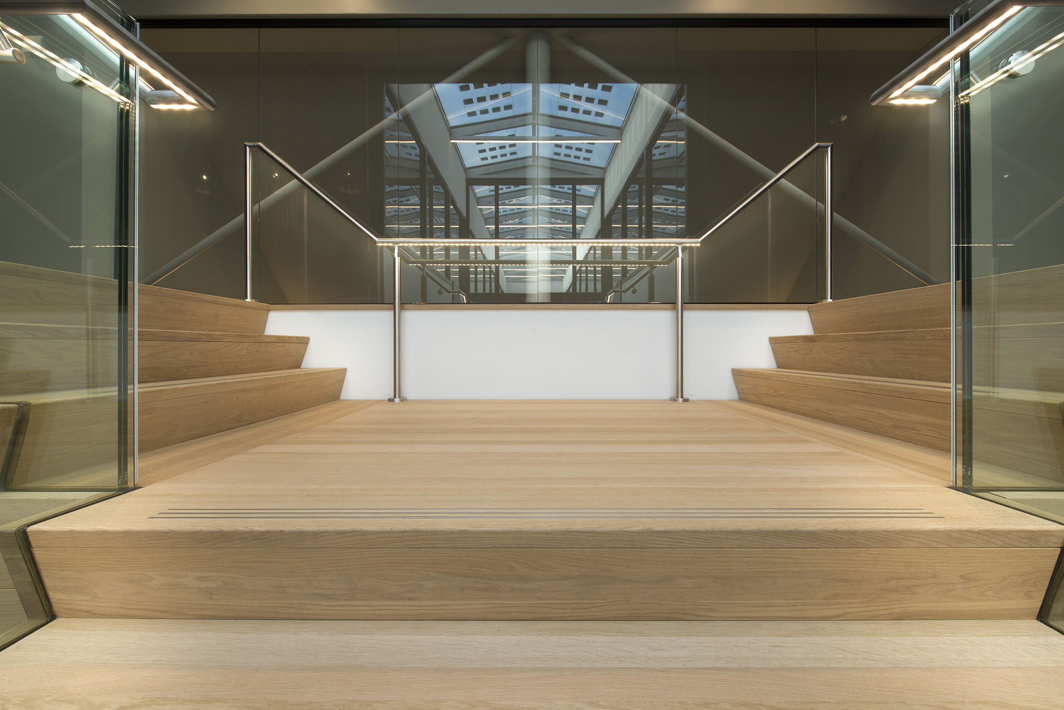 Trapverlichting Huis van de Gemeente Wijchen. De ILLUNOX leuningen zijn gemonteerd op de glazen balustrade. De trap staat in de centrale hal en is een echte eye-catcher.